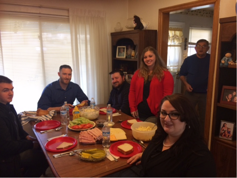Veterans Advocacy Clinic Students (from left) James Dorsey, Alex Jonese, C.J. Reid, Kirsten Lilly and Rachel Roush, pose during a lunch graciously provided by United States Marine Corps Veteran Joe Gero (in doorway), of Madison, during the students’ visit to VFW Post 5578. 